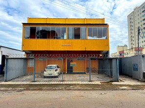 A two-story building with a yellow facade and a sign reading "Ed. Gervásio". - EDIFICIO GERVASIO (Goiania)