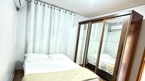 Une chambre d’hôtel équipée d’un lit, d’un bureau, d’une armoire et d’un appareil de climatisation.