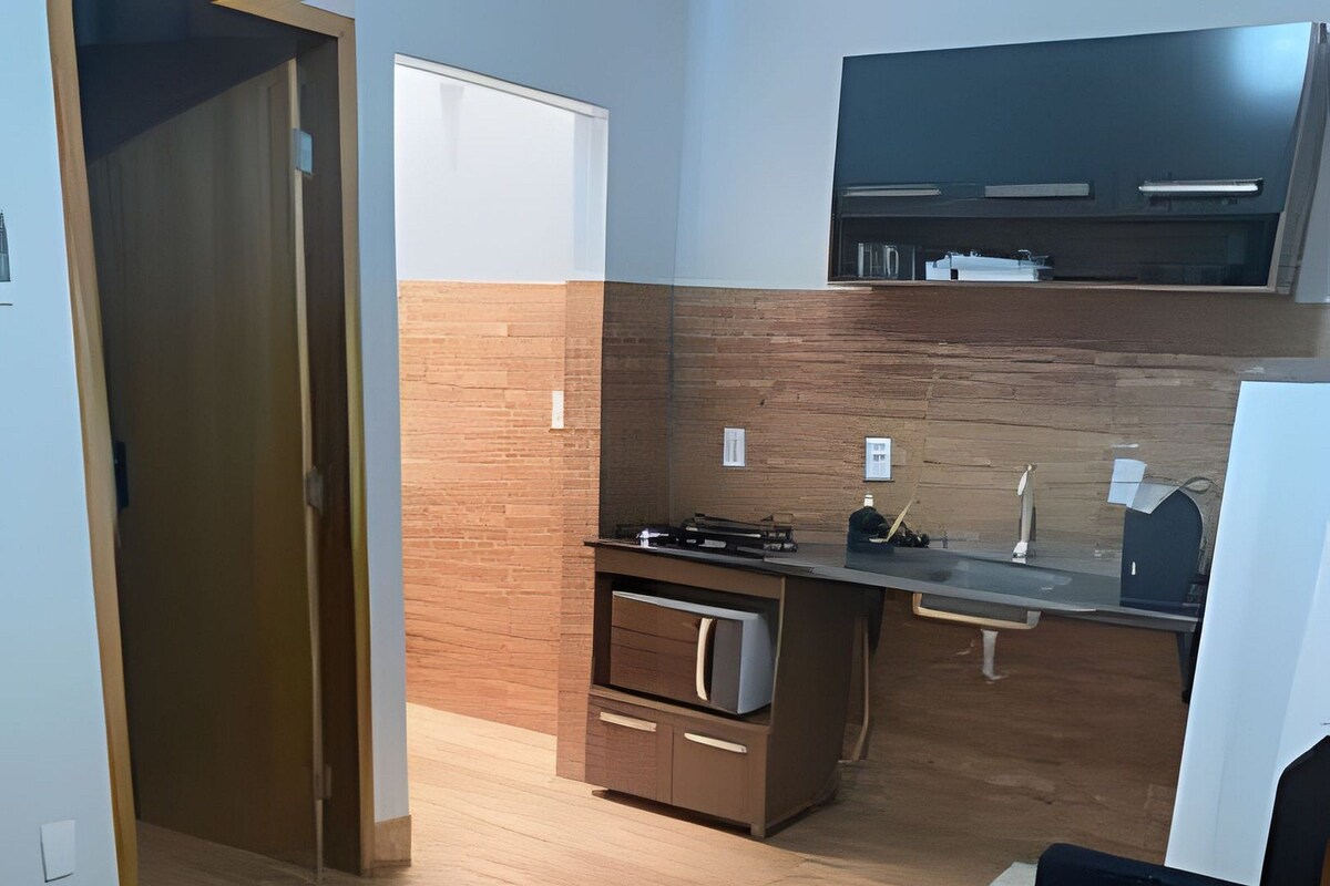 A modern kitchen with a built-in oven, a countertop, and a black chair.