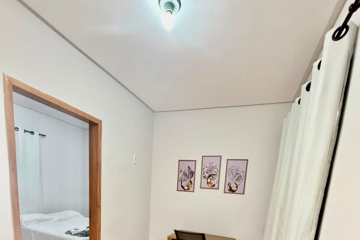 A room with a bed, a desk, and three framed pictures on the wall.