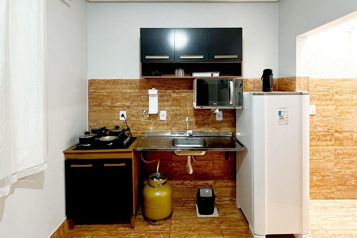 A compact kitchen with a gas stove, microwave, and refrigerator.