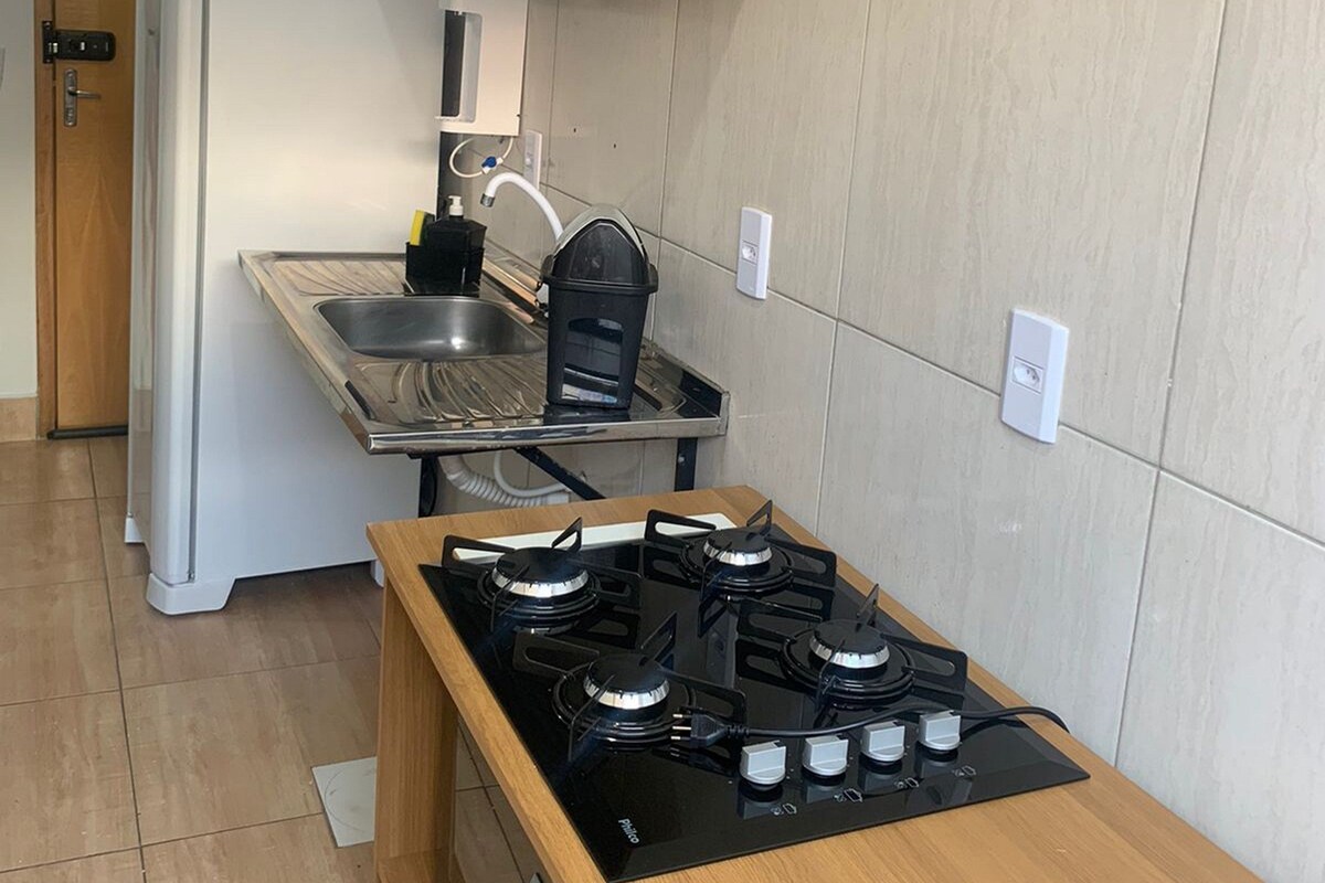 A compact kitchen with a gas stove, a sink, and a refrigerator.