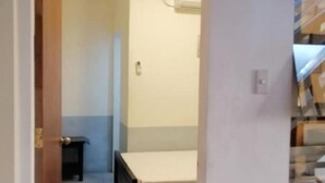 A bedroom with a bed, a small bedside table, and a wall-mounted air conditioning unit. - RedDoorz @ Bansud Oriental Mindoro (Bansud)