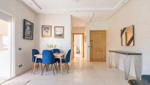 Un comedor moderno con una mesa y sillas, una consola y obras de arte enmarcadas en las paredes.