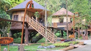 Treehouse accommodations with wooden staircases and platforms. - Safari Resort (Cisarua)
