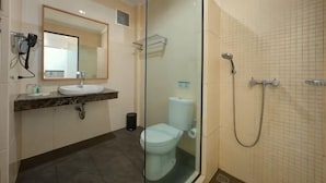 A bathroom with a glass-enclosed shower, a sink, and a toilet. - Safari Resort (Cisarua)