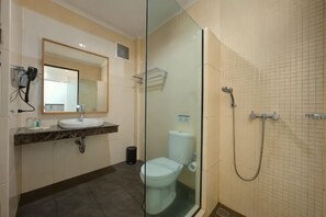 Casa de banho com cabine de duche em vidro, uma pia e sanita.