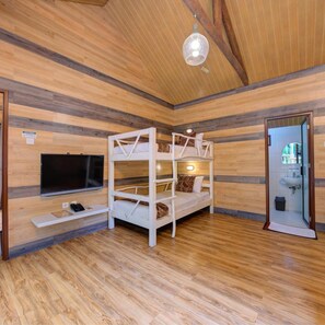 A room with a bunk bed, a flat-screen TV, and a wooden floor. - Safari Lodge Hotel (Cisarua)