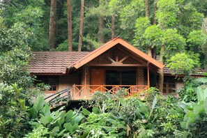 A wooden cabin with a balcony, surrounded by dense forest. - Safari Lodge Hotel (Cisarua)