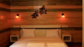 A bedroom with a wooden headboard, a bed with white linens, two bedside tables, and wall-mounted lamps.