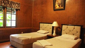 A room with two beds, a window with a view, and a lamp on a nightstand. - Safari Lodge Hotel (Cisarua)
