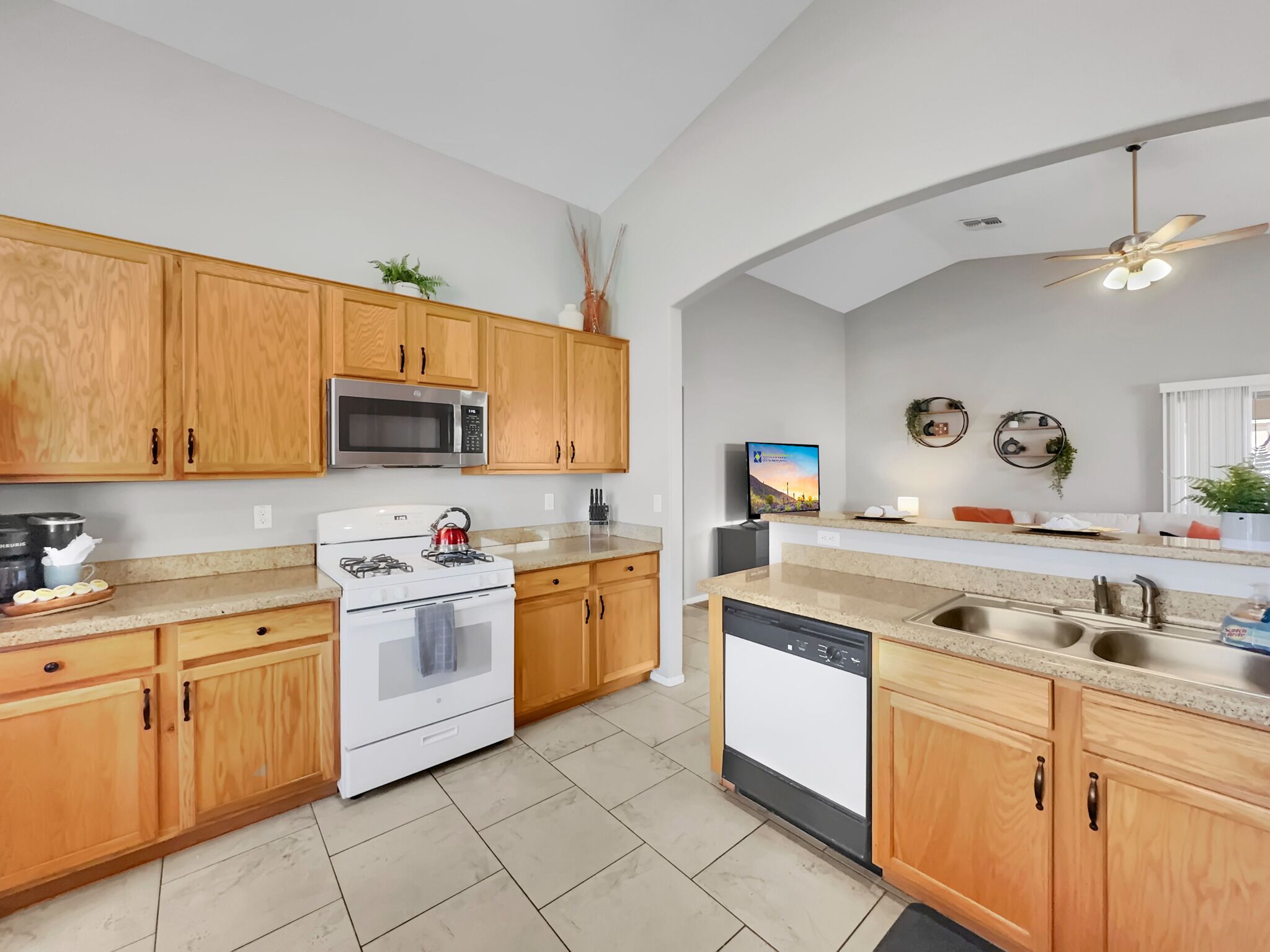 A modern kitchen with wooden cabinets, a stainless steel microwave, a gas stove, and a dishwasher.