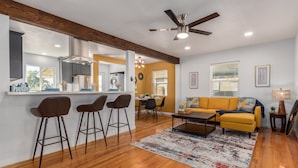 A modern living room with a sofa, coffee table, and bar stools. - 14th Coronado Historic District Phoenix (Phoenix)