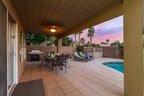 An outdoor patio with a pool, a grill, and lounge chairs. - Baylor Gilbert (Gilbert)