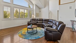A spacious living room with a large sectional sofa, a round coffee table, and a colorful rug. - Sinagua Heights Flagstaff (Flagstaff)