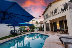 A swimming pool with a patio area, outdoor furniture, and a building with a balcony. - 73rd Glendale (Glendale)