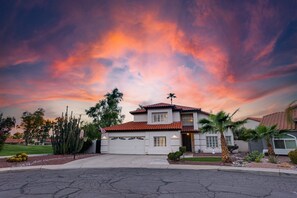A two-story house with a red-tiled roof, a garage, and a front yard with cacti and palm trees. - 73rd Glendale (Glendale)