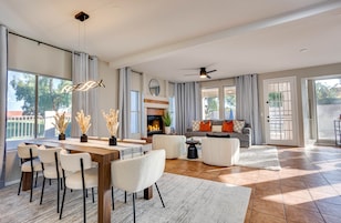 Un salón amplio con comedor, ventanas grandes y chimenea.