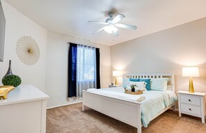 A bedroom with a bed, nightstands, a ceiling fan, a decorative wall piece, and a window with curtains. - Southern #2067 Mesa (Mesa)