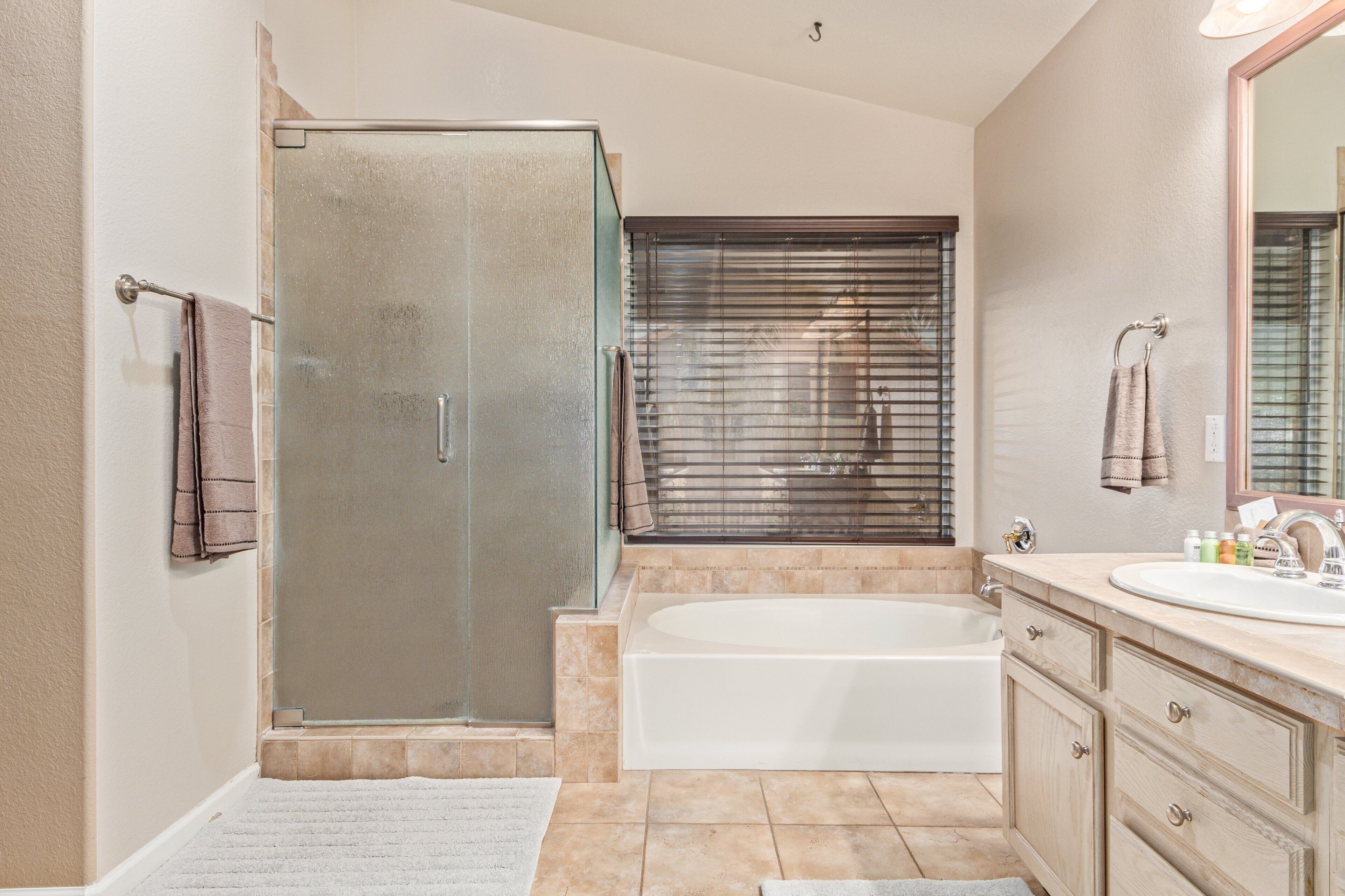 Une salle de bain dotée d’une douche à parois de verre, d’une baignoire et d’un meuble-lavabo avec un évier.
