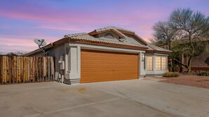 A single-story house with a garage, a satellite dish, and a wooden fence. - Emile Zola Peoria (Peoria)