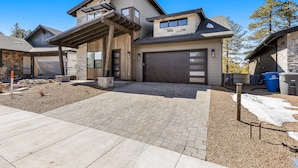 A modern two-story house with a garage, a covered patio, and a landscaped driveway. - Cottonrose Flagstaff (Flagstaff)