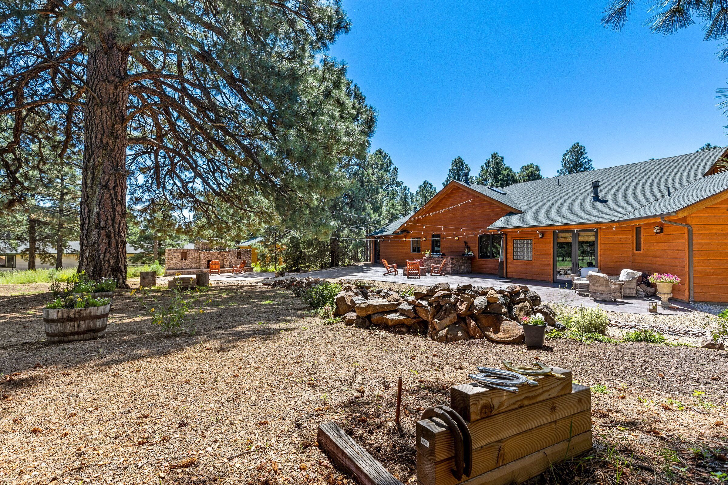 A lodge with a wooden exterior, outdoor seating, and a stone fire pit.