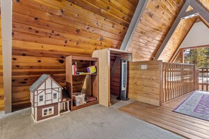Interior de madera con una maqueta de casa, un calentador y una terraza de madera.