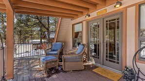 Un espacio de estar techado al aire libre con muebles de mimbre y un letrero que dice 'Welcome'.
