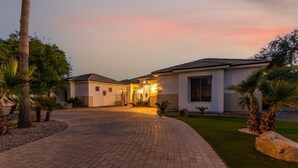 A two-story house with a paved driveway leading to a gated entrance. - Tonto Chandler (Chandler)