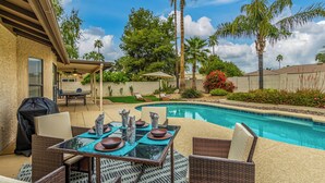 A backyard with a swimming pool, outdoor furniture, and a barbecue grill. - Beverly Scottsdale (Scottsdale)