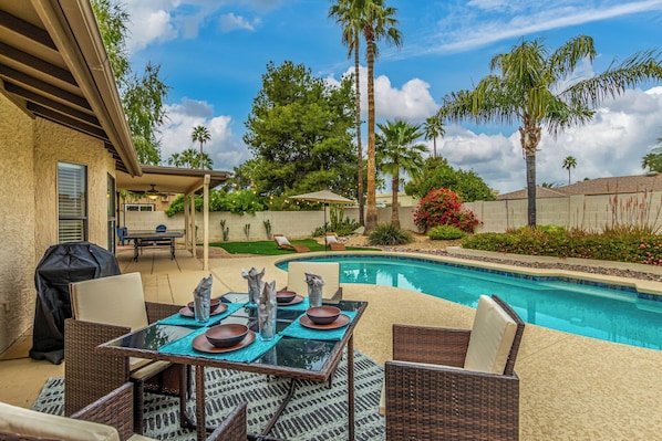 A backyard with a swimming pool, outdoor furniture, and a barbecue grill. - Beverly Scottsdale (Scottsdale)