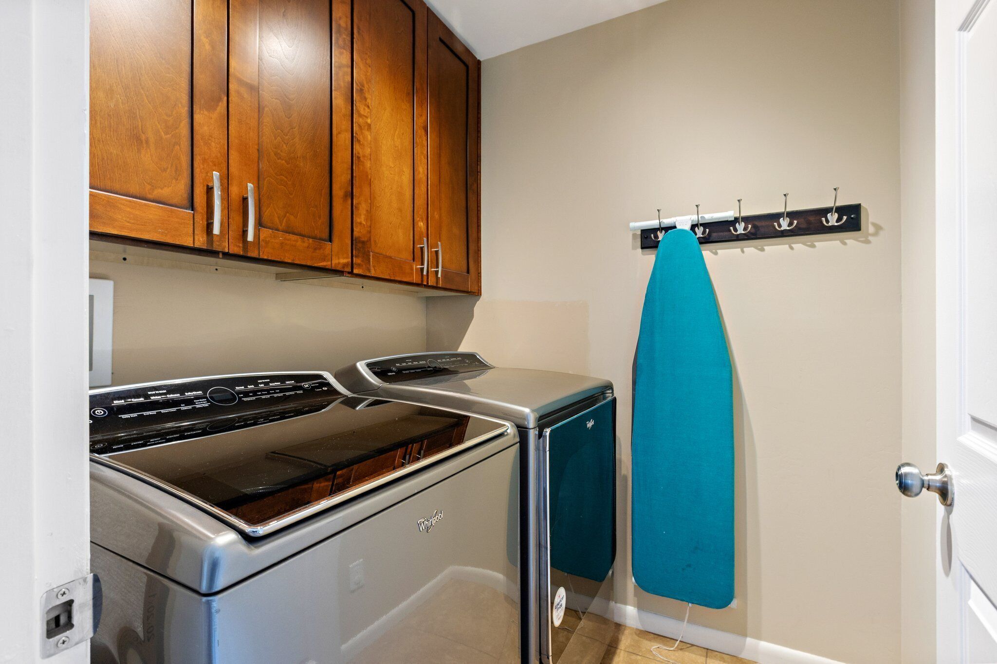 A compact kitchen with wooden cabinets, a built-in oven, and a wall-mounted drying rack.