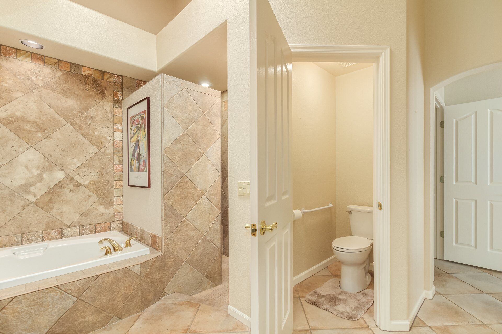 A bathroom with a bathtub, toilet, and shower area.