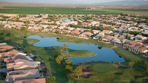 A residential area with houses, a golf course, and a large body of water. - Michigan Sun Lakes (Chandler)
