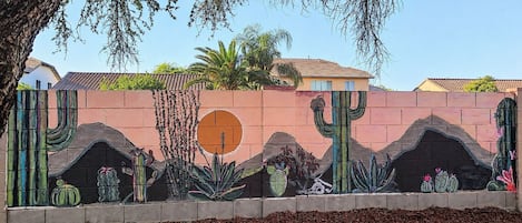 A mural with cacti and desert plants on a wall.