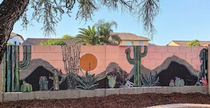 A mural with cacti and desert plants on a wall.