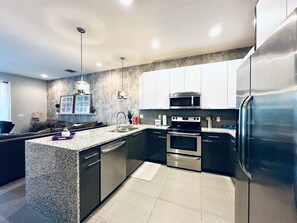 Una cucina moderna con piani in granito, elettrodomestici in acciaio inossidabile e forno integrato.