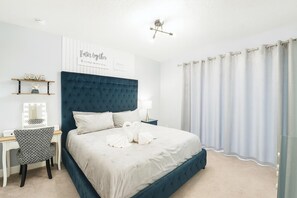Un dormitorio con una cama grande, un tocador con espejo y un estante de pared con adornos.