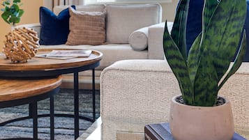 A modern living room with a sofa, coffee table, and a potted plant.