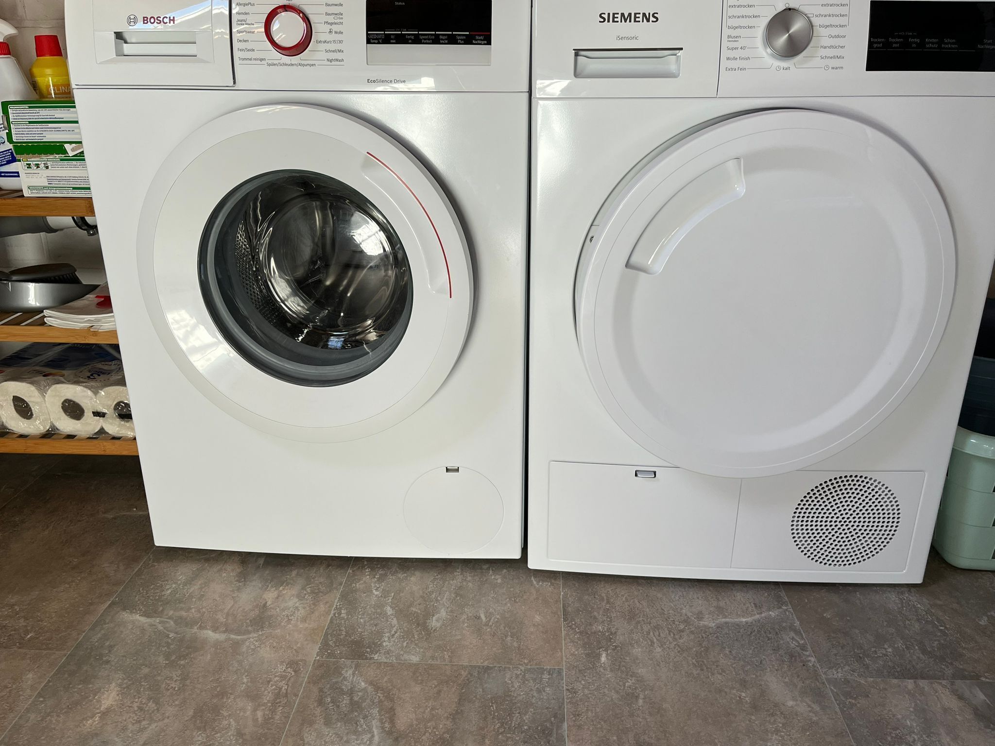Two white washing machines, one with a Bosch logo and the other with a Siemens logo, placed side by side.