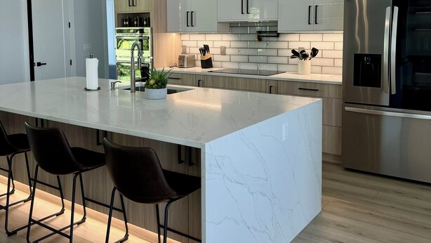 A modern kitchen with a large island, stainless steel appliances, and pendant lighting. - Hidden Gem with Jacuzzi, Waterfront   (North Port)
