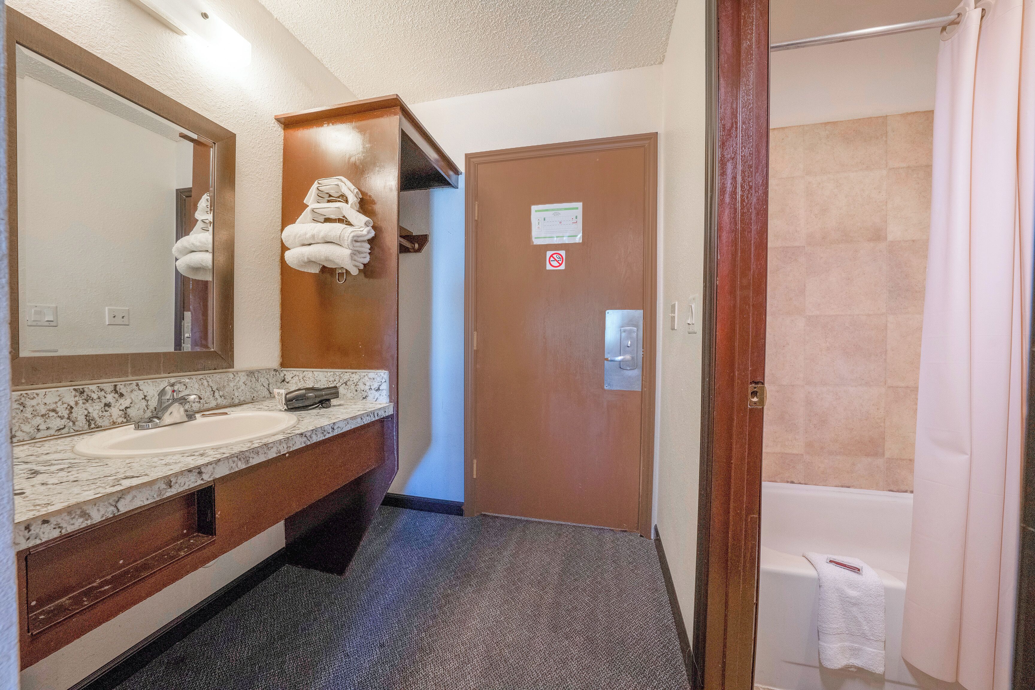 A bathroom with two sinks, a mirror, a towel rack, and a shower.