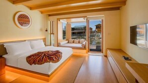 A modern hotel room with a large bed, a seating area with a view, and a TV on a wooden console. - Lugu Lake Mosuo Home Hotel (Yanyuan)