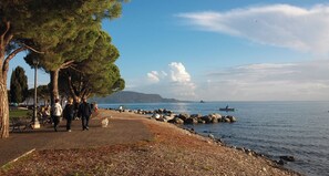 A coastal walkway with benches, trees, and a rocky shoreline. - Casa Fornico 2, with terrace and partial lake view in quiet position (Lombardia)