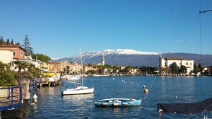 A marina with boats, a hotel, and a mountain in the background. - Casa Fornico 2, with terrace and partial lake view in quiet position (Lombardia)