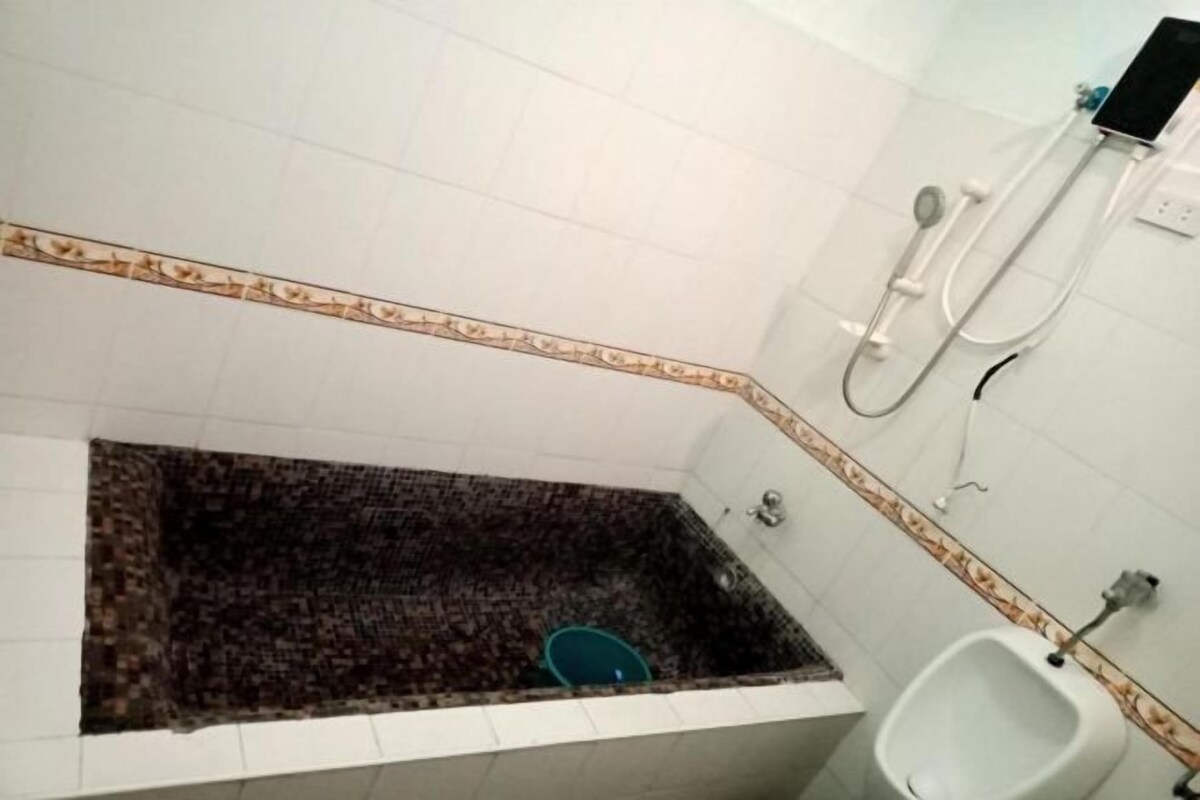 Un baño con bañera, orinal y ducha.