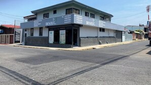 A two-story building with a sign reading "DENTIX". - Apartamentos Yusem #3

 (Alajuela)