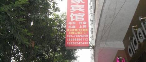 A vertical sign with contact information for a family guesthouse.