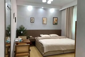 A hotel room with a bed, bedside table, lamp, and wall art. - Wulong Youjia Hotel (Chongqing)